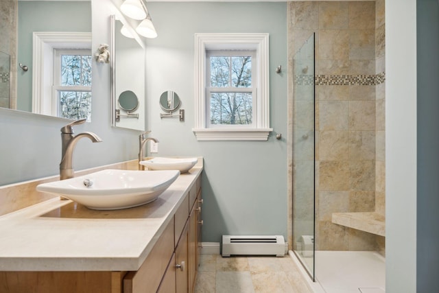 bathroom featuring a baseboard heating unit, a tile shower, and vanity