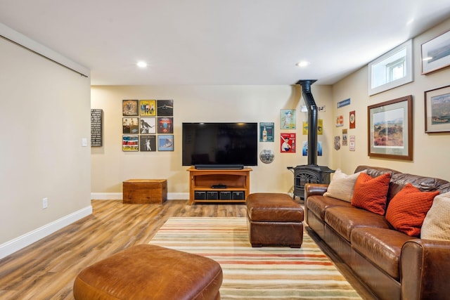 living room with a wood stove and light hardwood / wood-style flooring