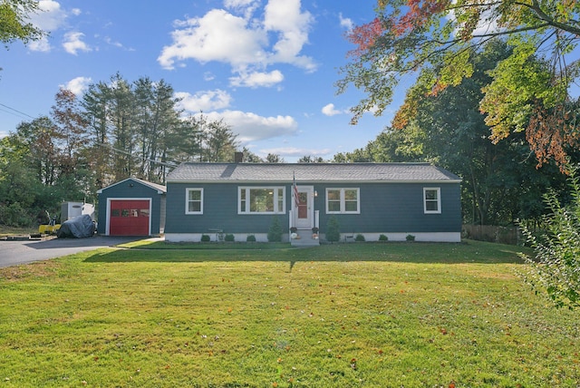 ranch-style home with a front yard, a garage, and an outbuilding