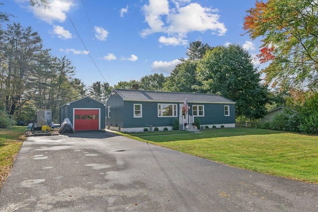 single story home featuring an outbuilding, a front yard, and a garage