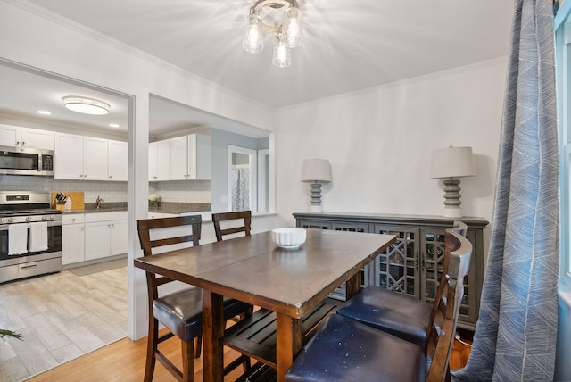 dining space with light wood-type flooring and crown molding