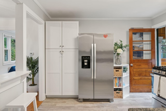 kitchen with stainless steel appliances, white cabinetry, and ornamental molding