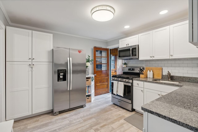 kitchen featuring stainless steel appliances, white cabinets, and tasteful backsplash