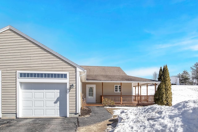 view of front of property with an attached garage, covered porch, and driveway