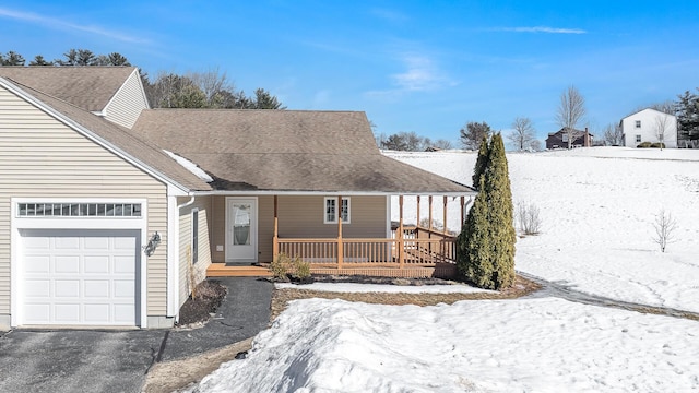 view of front of property featuring a porch, an attached garage, and roof with shingles