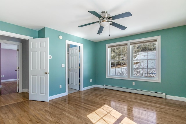 unfurnished bedroom featuring a ceiling fan, wood finished floors, baseboards, and a baseboard radiator