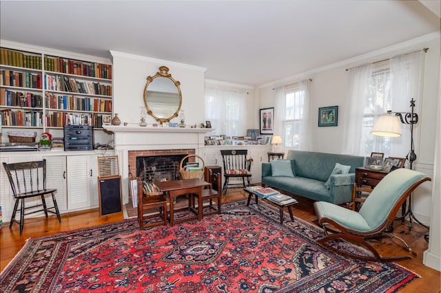 living room featuring a fireplace, hardwood / wood-style floors, and crown molding