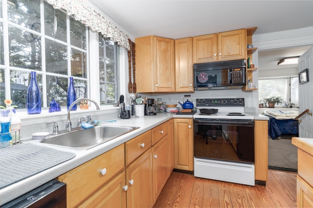 kitchen featuring sink, light hardwood / wood-style floors, black appliances, and light brown cabinets