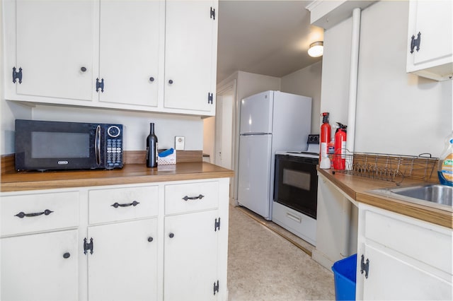 kitchen featuring range with electric cooktop, white cabinets, white fridge, and sink