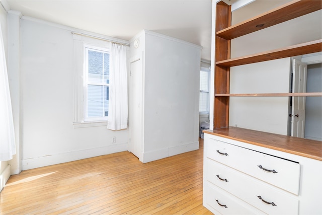 interior space featuring ornamental molding and light hardwood / wood-style floors