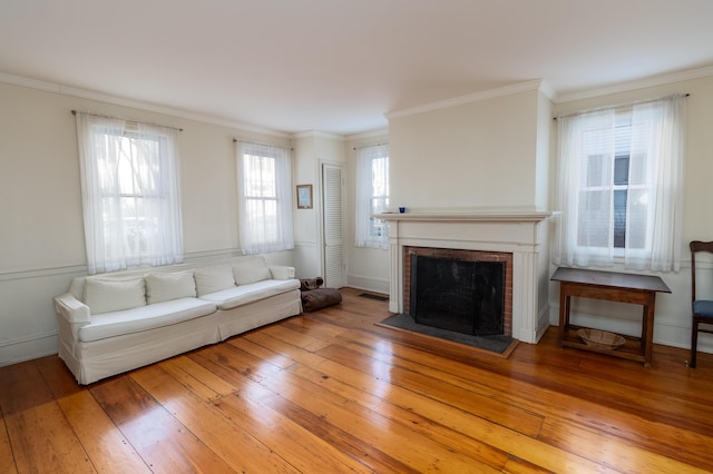 unfurnished living room with a fireplace, crown molding, and light hardwood / wood-style flooring