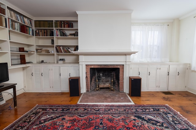 living room with a fireplace, crown molding, and light hardwood / wood-style flooring