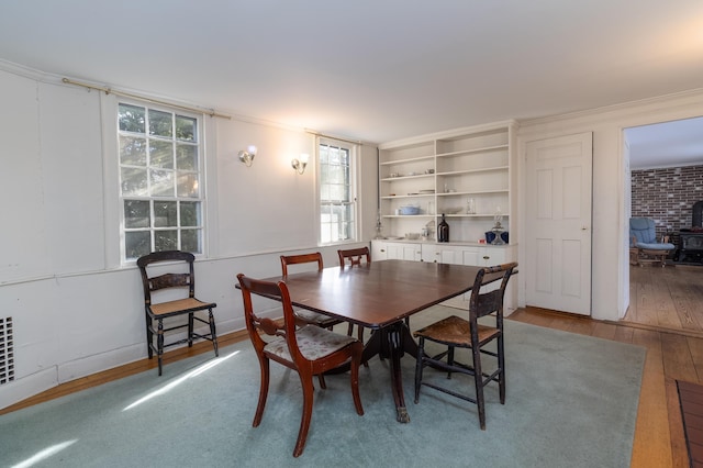 dining area featuring ornamental molding and wood-type flooring