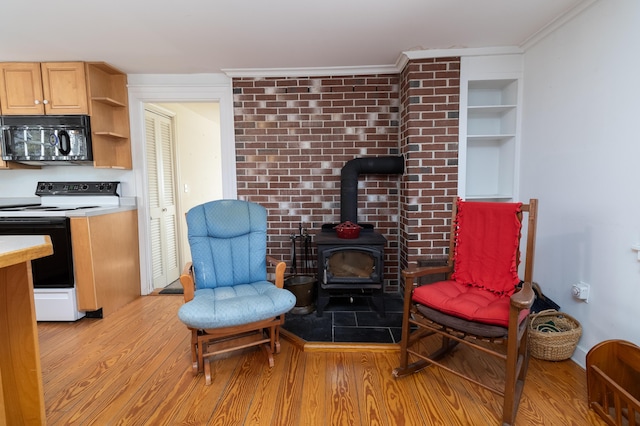 living area with ornamental molding, a wood stove, and light hardwood / wood-style flooring