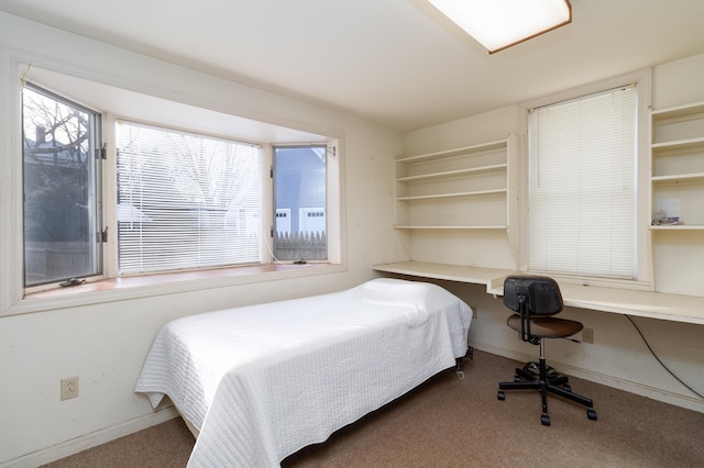 carpeted bedroom with built in desk