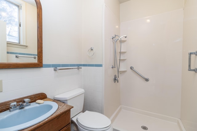 bathroom featuring tile walls, a shower, vanity, and toilet