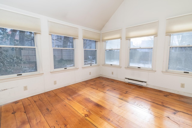 unfurnished sunroom featuring a baseboard heating unit, vaulted ceiling, and a wealth of natural light