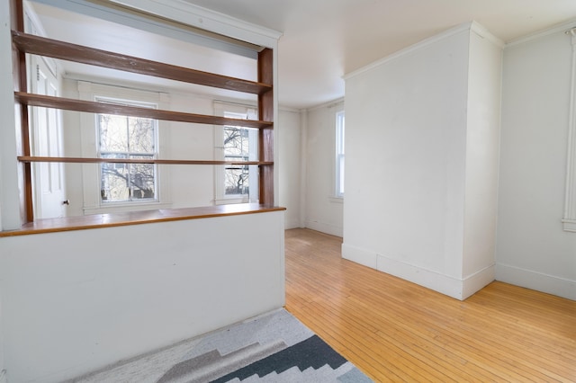 bar with light hardwood / wood-style floors, ornamental molding, and a wealth of natural light