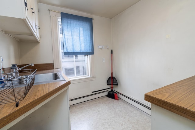 laundry room featuring a baseboard radiator and sink