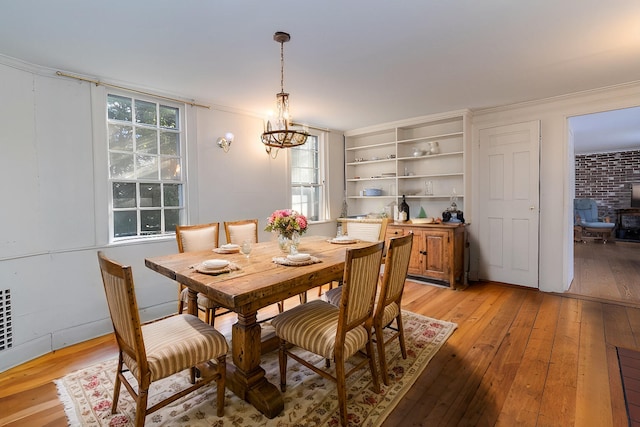 dining space featuring a chandelier, crown molding, and light hardwood / wood-style flooring