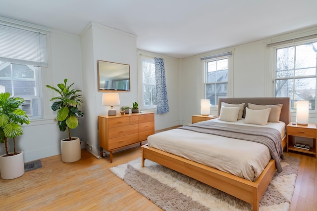 bedroom featuring light hardwood / wood-style flooring and multiple windows