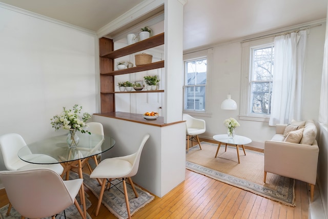 dining area featuring light hardwood / wood-style floors and crown molding