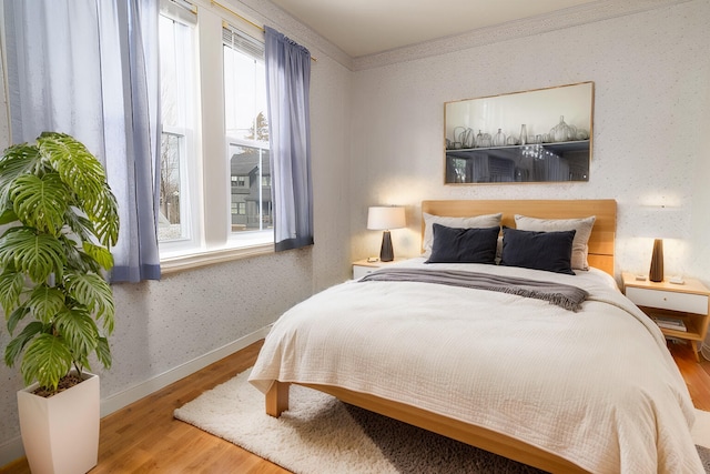 bedroom with crown molding and hardwood / wood-style flooring