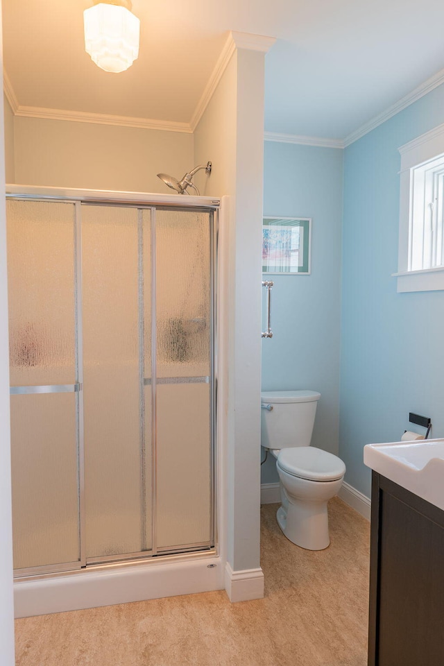 bathroom featuring a shower stall, crown molding, toilet, vanity, and baseboards