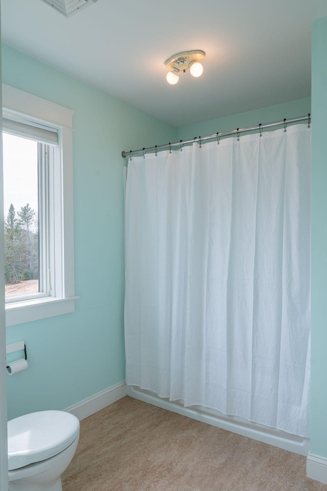 full bath featuring toilet, baseboards, and a shower with curtain