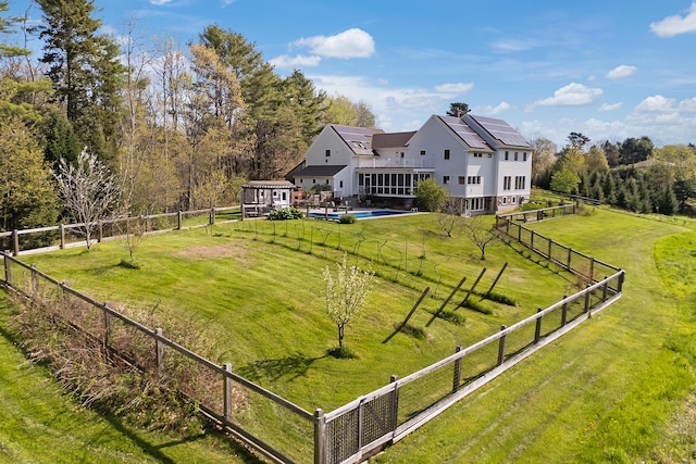 rear view of house with solar panels, a rural view, and a wooden deck