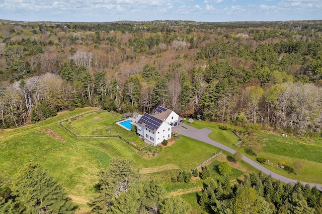 view of subject property featuring a heavily wooded area and a pool area
