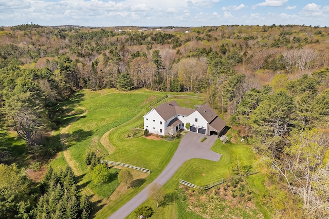 aerial view of property and surrounding area featuring a heavily wooded area