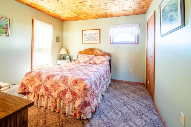 carpeted bedroom featuring multiple windows and wooden ceiling