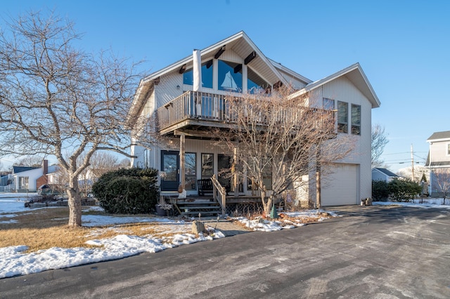 view of front of home with a garage, a balcony, and covered porch