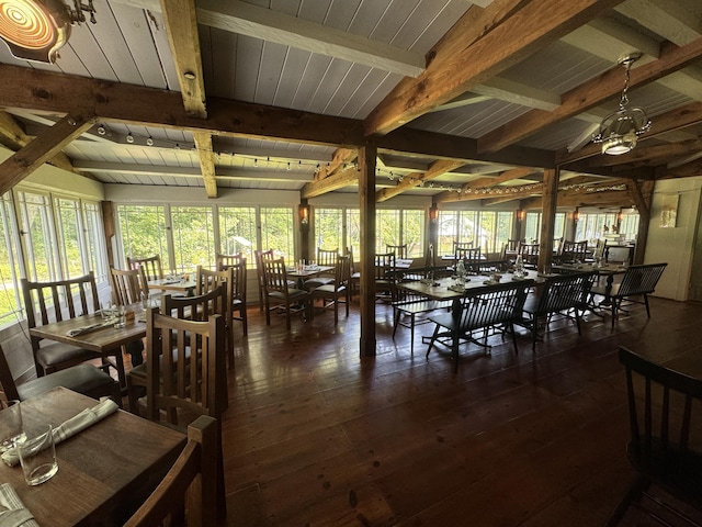 dining area with dark wood-type flooring, lofted ceiling with beams, and plenty of natural light