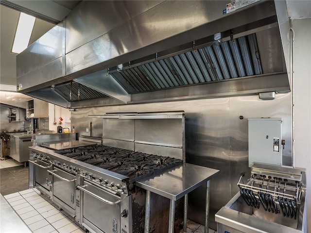 kitchen with dishwasher, light tile patterned floors, range hood, lofted ceiling, and backsplash