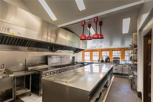 kitchen with a large island, stainless steel counters, light tile patterned floors, decorative backsplash, and high vaulted ceiling