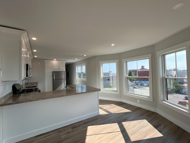 kitchen with stainless steel appliances, white cabinets, a healthy amount of sunlight, and kitchen peninsula