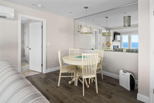 dining space featuring a wall unit AC, a water view, an inviting chandelier, and dark hardwood / wood-style floors