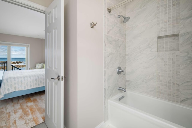 bathroom with tiled shower / bath combo and hardwood / wood-style flooring