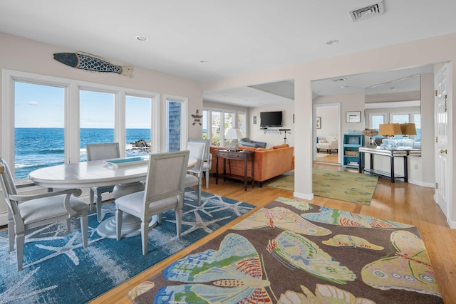 dining area featuring a water view and hardwood / wood-style flooring