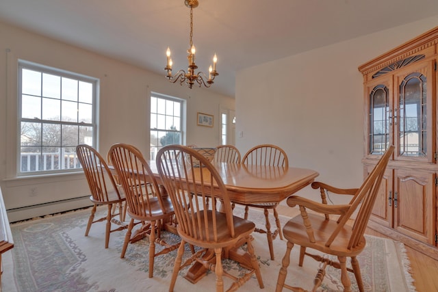 dining area featuring light wood-type flooring, a baseboard heating unit, and a chandelier