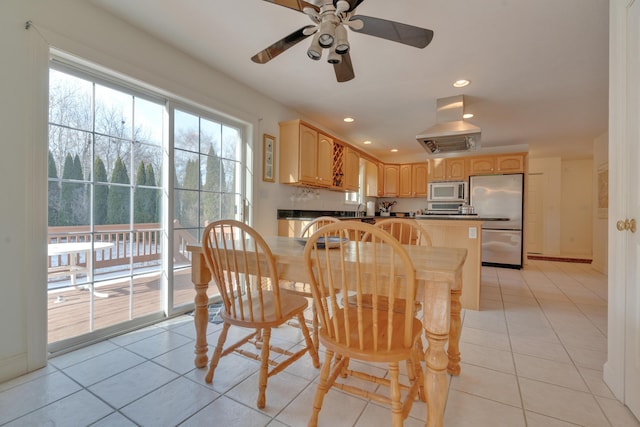 tiled dining space with ceiling fan and sink