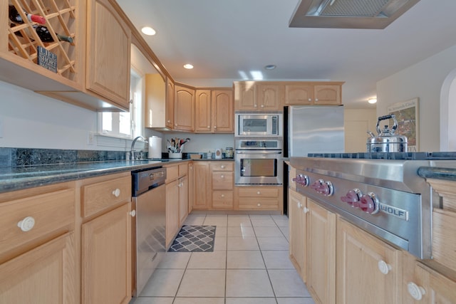 kitchen featuring light tile patterned floors, light brown cabinetry, sink, and stainless steel appliances