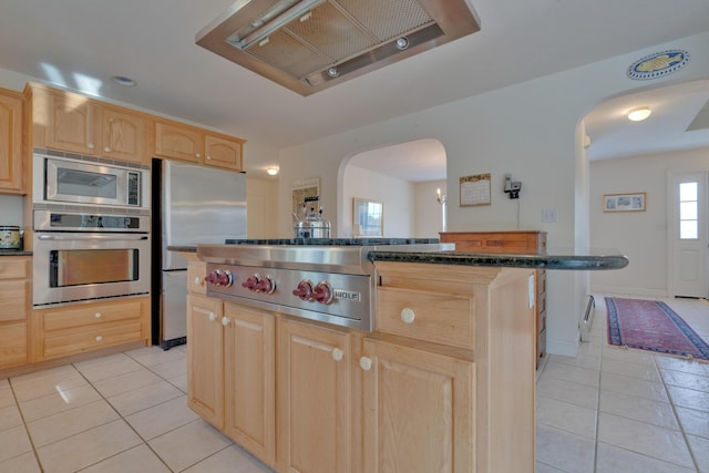 kitchen featuring light brown cabinetry, appliances with stainless steel finishes, custom range hood, and a kitchen island