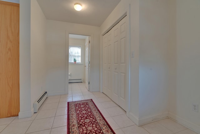 hallway with light tile patterned floors and a baseboard heating unit