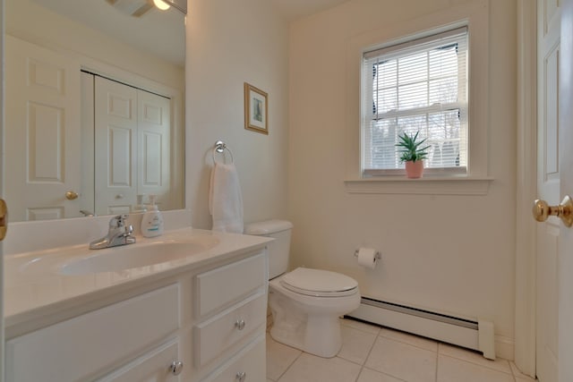 bathroom with tile patterned flooring, vanity, a baseboard heating unit, and toilet