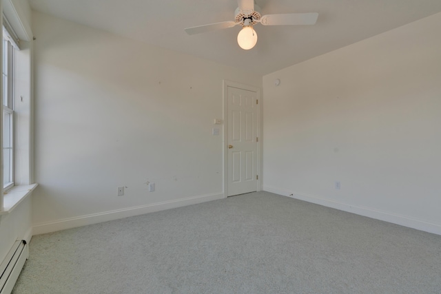 carpeted empty room with ceiling fan, baseboard heating, and a healthy amount of sunlight