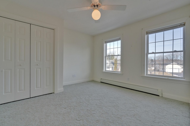 unfurnished bedroom featuring ceiling fan, a baseboard heating unit, and a closet