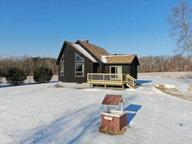 snow covered property with a deck